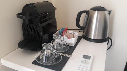 a coffee maker and two glass jars on a counter at Azienda Agricola I Peperoncini in Alghero