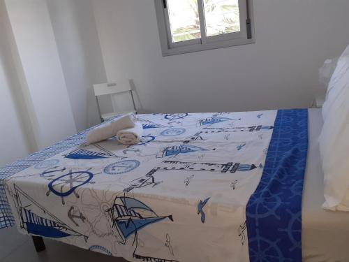 a bed with a blue and white comforter on it at Hydra Ground 1D in Puerto de Mazarrón