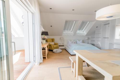 ein Schlafzimmer mit einem Bett und einem Tisch in einem Zimmer in der Unterkunft Belle Maison - Das kleine Hotel in Werbach