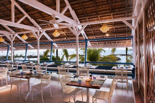 a restaurant with tables and chairs and a view of the ocean at Veranda Pointe Aux Biches Hotel & Spa in Trou aux Biches