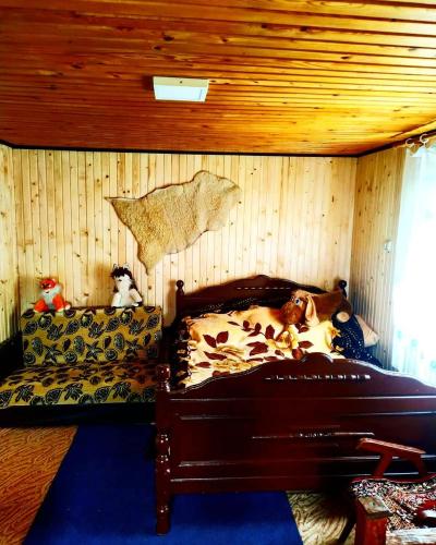 a dog laying on a bed in a room at Садиба у пані Марії in Vorokhta
