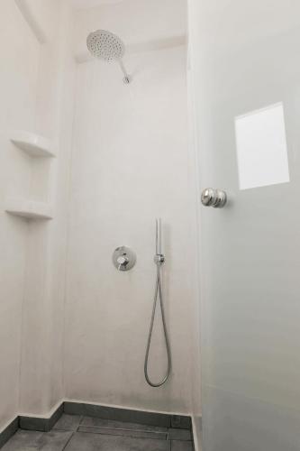 a shower stall with a shower head in a bathroom at Eternity Suites Santorini in Fira