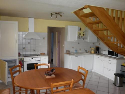 una cocina con mesa y sillas y una escalera en Gîte Clévacances dans le Finistère, en Scrignac