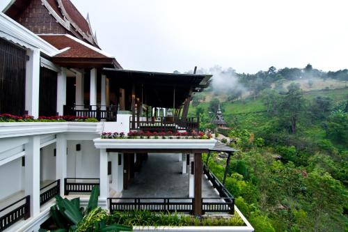 a building with a balcony with flowers on it at Panviman Chiang Mai Spa Resort in Mae Rim