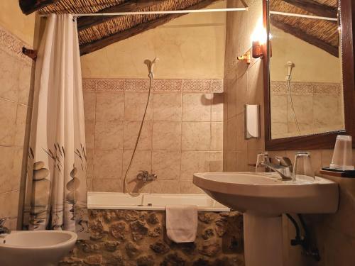 a bathroom with a sink and a shower with a tub at Alojamiento Rural Casa Honda in Ayna