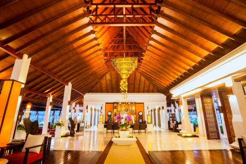a lobby with a large wooden ceiling and a chandelier at Panviman Chiang Mai Spa Resort in Mae Rim