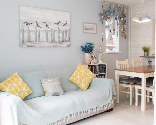 a living room with a blue couch and a table at Wendy House in Eastbourne