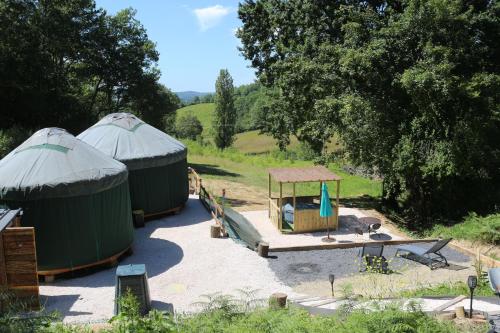 twee hutten met een speeltuin en een speelplaats bij yourtes coccinelles in Conchez-de-Béarn