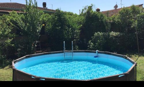 una gran piscina de agua azul en un patio en Casa Maya con giardino privato, en Torre del Lago Puccini