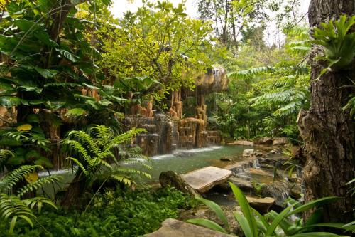 a waterfall in the middle of a forest at Panviman Chiang Mai Spa Resort in Mae Rim
