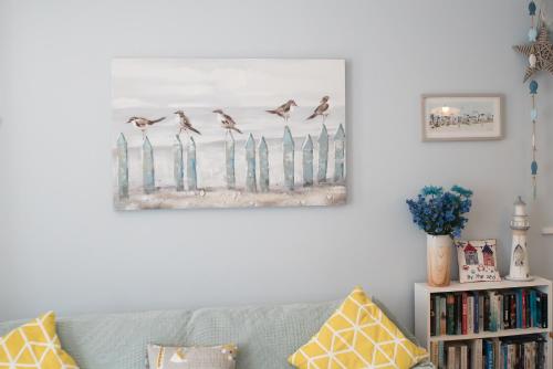 a living room with a couch and a picture of birds at Wendy House in Eastbourne