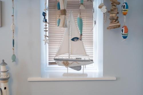 a small sailboat on a window sill in a room at Wendy House in Eastbourne