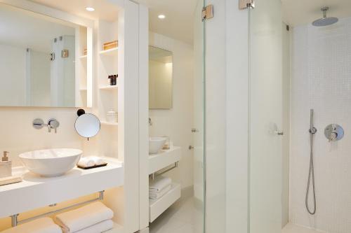 a white bathroom with two sinks and a shower at Vincci EverEden in Anavyssos