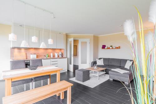 a living room with a couch and a table at Haus Calmsailing in Börgerende-Rethwisch