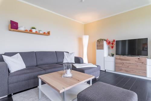 a living room with a couch and a table at Haus Calmsailing in Börgerende-Rethwisch