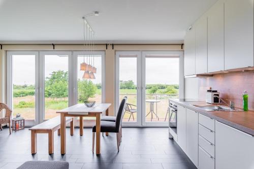 a kitchen with a table and a dining room at Haus Calmsailing in Börgerende-Rethwisch