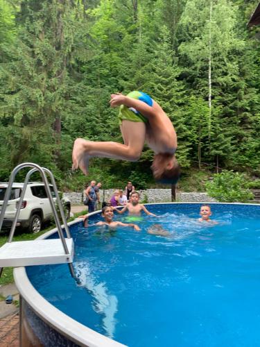 a person jumping into a swimming pool at Penzión Astoria in ľubochňa