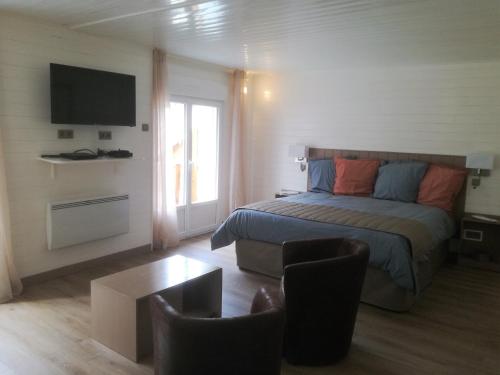 een slaapkamer met een bed, een tv en een tafel bij L Acacia in Lus-la-Croix-Haute