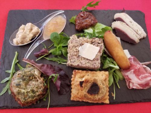 une plaque noire de nourriture avec de la viande et des légumes dans l'établissement L Acacia, à Lus-la-Croix-Haute