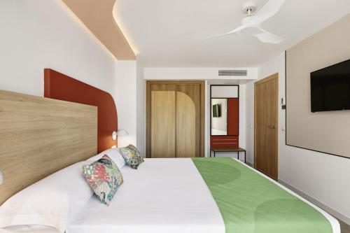 a bedroom with a bed and a tv on the wall at Hotel Riu Concordia in Playa de Palma