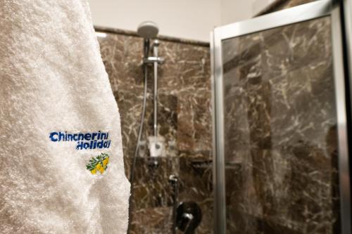 a bathroom with a shower with a white towel at Taormina Park Hotel in Taormina