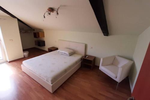 una camera con un letto bianco e una sedia di Nella vecchia Pescara a Pescara