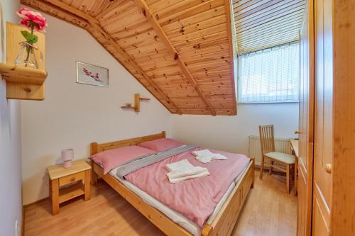 um quarto com uma cama e um tecto de madeira em Penzión Severka em Oravská Lesná