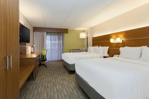 a hotel room with two beds and a television at Holiday Inn Express Milwaukee - West Medical Center by IHG in Wauwatosa