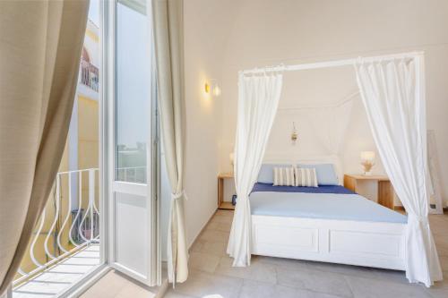 a bedroom with a bed and a balcony at Le Volte Procida Home in Procida