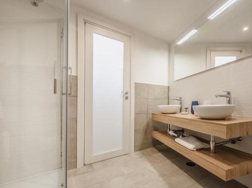 a bathroom with two sinks and a walk in shower at Le Volte Procida Home in Procida
