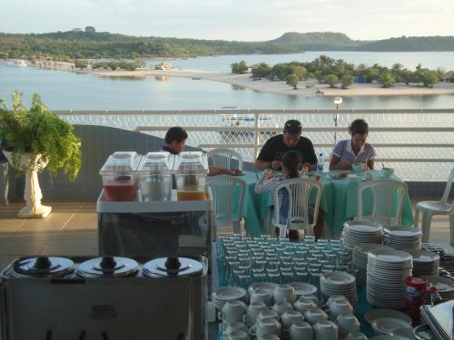 a group of people sitting at a table on a balcony at Hotel Mirante Da Ilha in Alter do Chao
