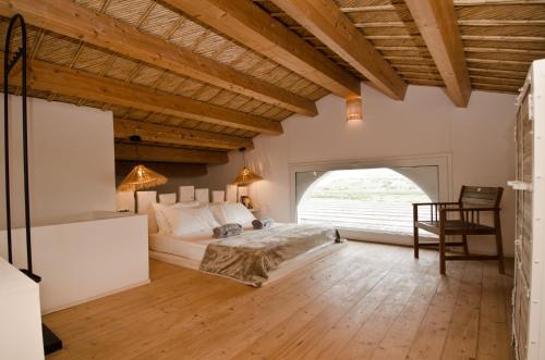 a bedroom with a bed and a large window at Kapuhala Sicily in Marzamemi