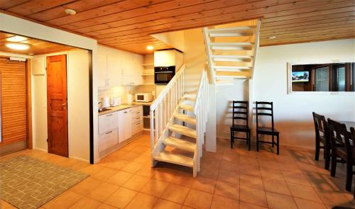 a room with a staircase and a kitchen with chairs at Zone Apartments in Ruka