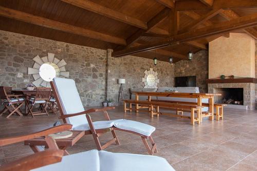 sala de estar con mesa, sillas y chimenea en Casa Cal Saboya, en L'Espunyola