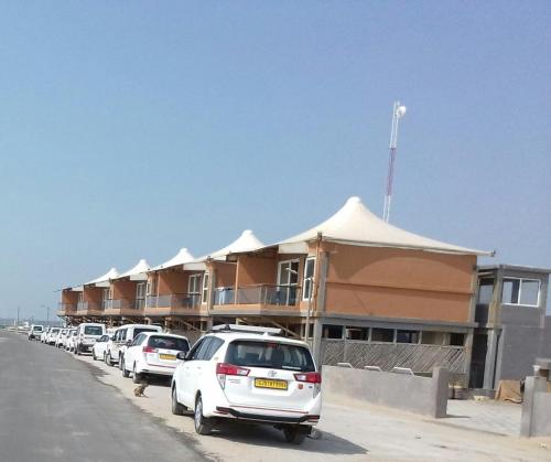 a line of cars parked in front of a building at The Fern Leo Beach Resort , Madhavpur in Porbandar