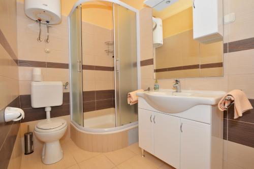 ein Bad mit einem WC, einem Waschbecken und einer Dusche in der Unterkunft Apartments Jovic in Makarska