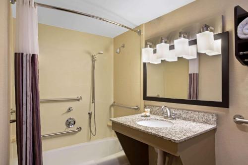 a bathroom with a sink and a shower and a tub at La Quinta by Wyndham Springfield in Springfield