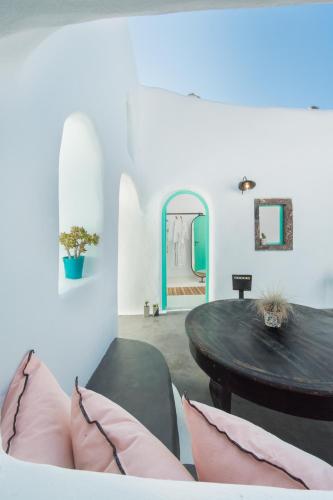 a dining room with a table and pink pillows at Sophia Finikia Villas in Oia