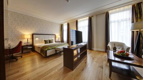 ein Hotelzimmer mit einem Bett und einem Wohnzimmer in der Unterkunft Kleiner Rosengarten in Mannheim