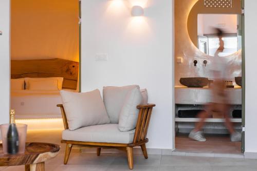 a living room with a chair and a bed at Eternity Suites Santorini in Fira