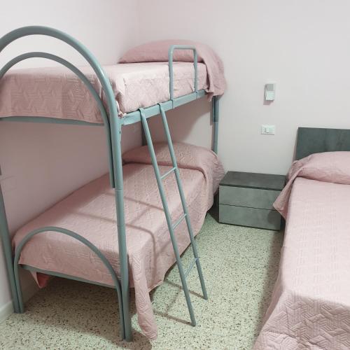 two bunk beds in a room with pink sheets at Green House in Fondi