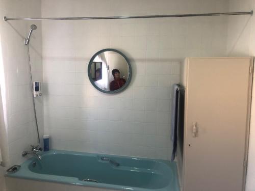 a man taking a picture of a bath tub in a bathroom at Jolani 2 Guest House in Welkom