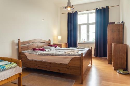 a bedroom with a bed with blue curtains and a window at TATRYSTAY Apartment Milo in Nový Smokovec