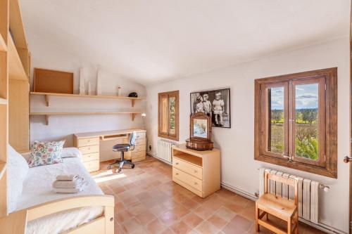 a bedroom with a bed and a desk and a window at Son Galiana in Algaida