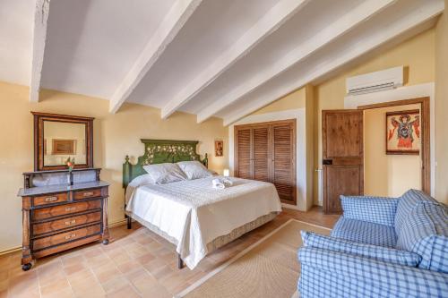 a bedroom with a bed and a dresser and a couch at Son Galiana in Algaida