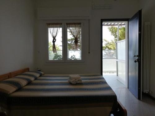 a bedroom with a large bed with two windows at Villaggio Turistico LA VESCA in Sanremo