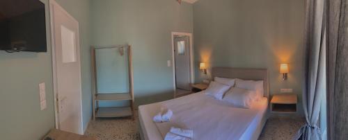 a bedroom with a bed with white sheets and pillows at Mpiritis Mare in Lefkandi Chalkidas