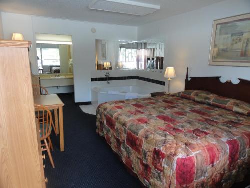 een hotelkamer met een bed en een bad bij Grand Rapids Inn in Grand Rapids