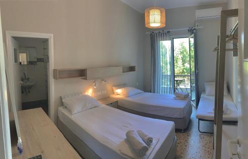 a hotel room with two beds and a bathroom at Mpiritis Mare in Lefkandi Chalkidas