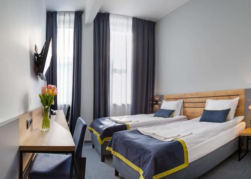 a hotel room with two beds and a table at Hotel Mokotów in Warsaw